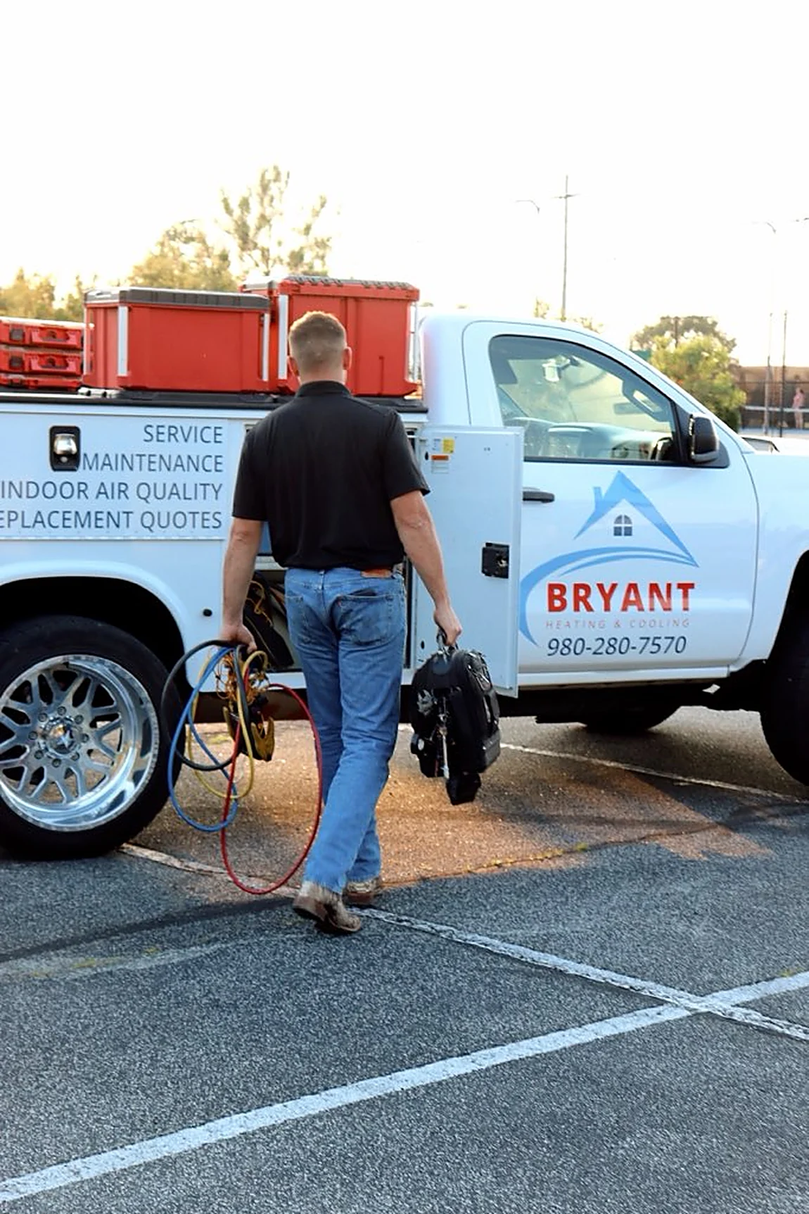 Bryant Heating and Cooling technician arriving on site with gauges and tools