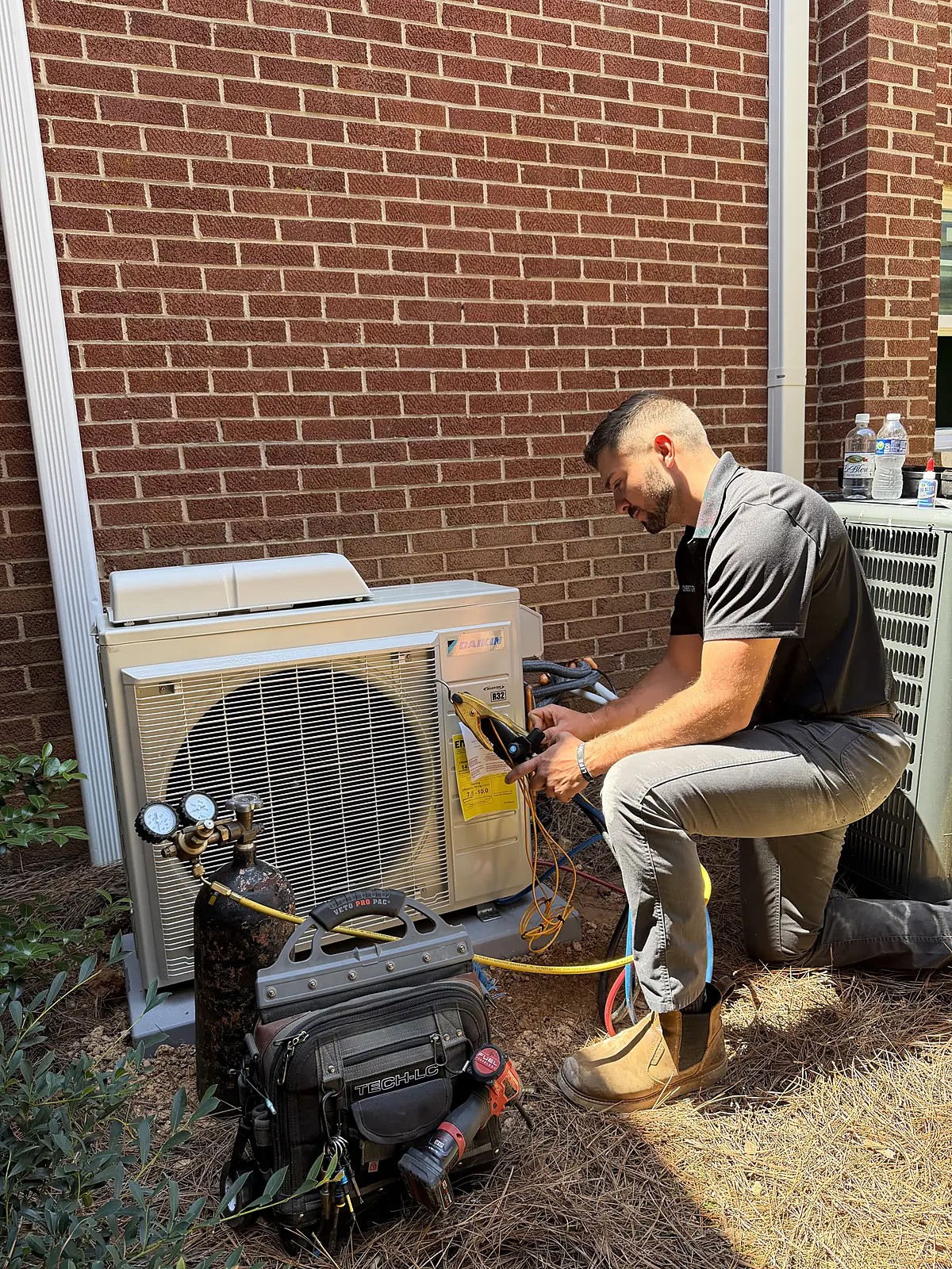 Christopher Bryant servicing an HVAC condenser unit